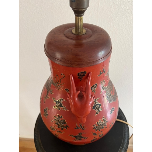 314 - A red ground Oriental vase with ornate dragon design and dragon head handles. H 44cm