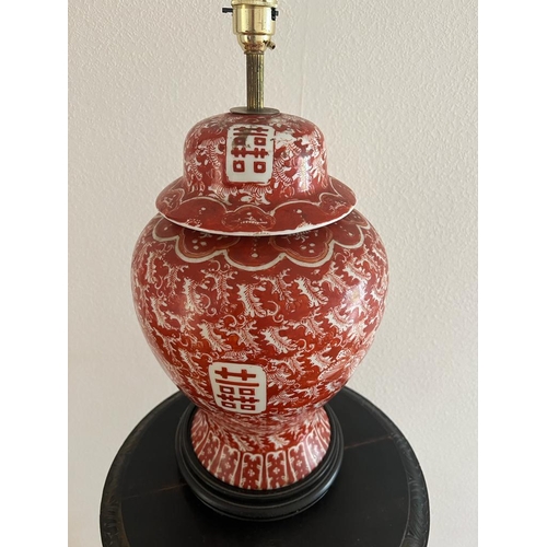 316 - An Oriental lamp base on wooden stand, red grounds H 49cm