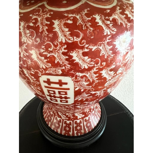 316 - An Oriental lamp base on wooden stand, red grounds H 49cm