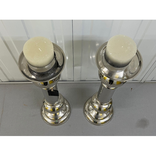 317 - Two chrome contemporary candlesticks Height 72cm.