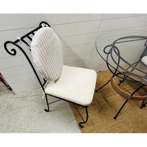 332 - A wrought iron glass top garden table with two wrought iron chair with cream cushions (H75cm Dia99cm... 