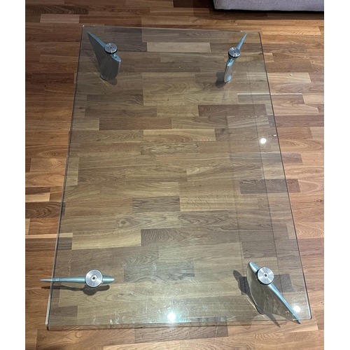 37 - A glass coffee table on shaped chrome legs (H29cm W115cm D77cm)