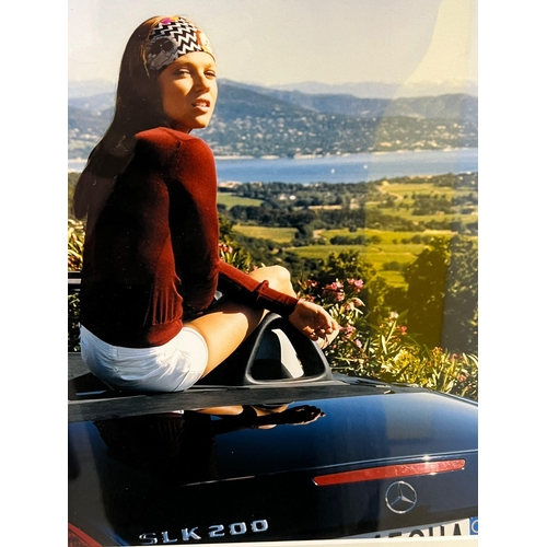 378 - Framed photograph of a lady sat on a Mercedes SLK 2000 (Framed size 48cm x 58cm)