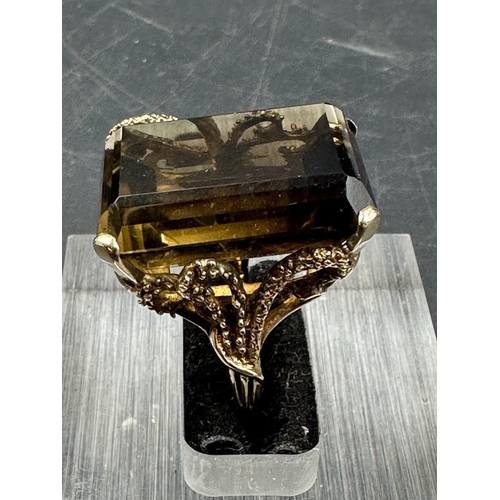 461 - A 9ct gold smokey quartz ring in an ornate setting.