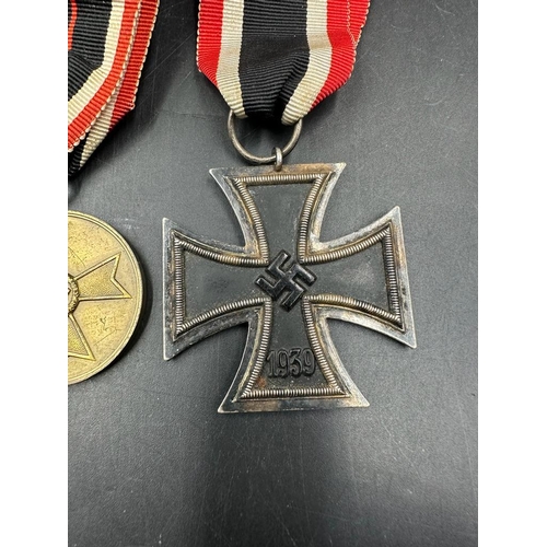 496 - Three German WWII medals to include A Merit Medal, War Merit Cross and an Iron Cross