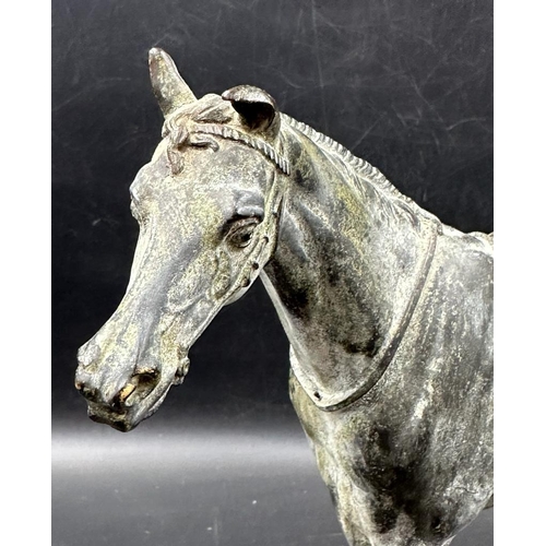 535 - A bronze of a saddled horse, unsigned (Approximate measurements 24cm H and 29cm L)