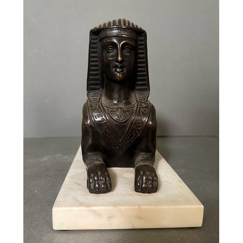 539 - A Bronze cast of a Sphynx with typical head-dress on a marble base (29cm x 12cm base)