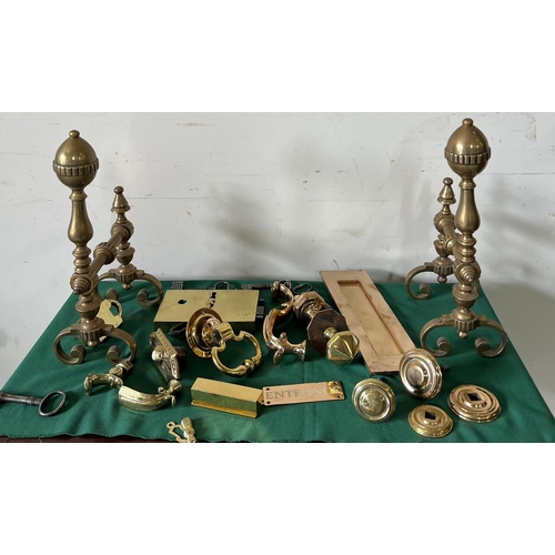 548 - A selection of brass ironmongery including door bell buttons, letterbox, door knockers and fire dogs... 