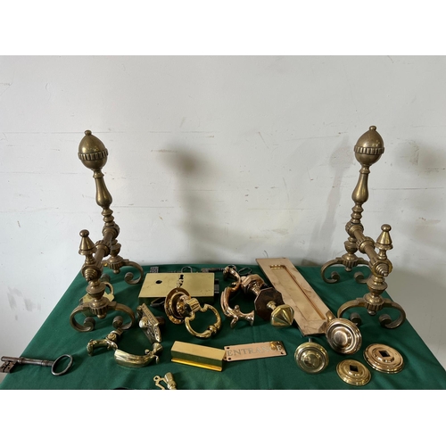 548 - A selection of brass ironmongery including door bell buttons, letterbox, door knockers and fire dogs... 