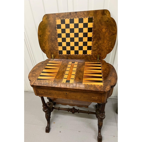 56 - A Victorian Burr Walnut Games Table. The table top opens to reveal Chess, back gammon and cribbage b... 