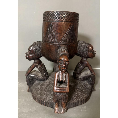 563 - A Heavy East African carved pot on stand. 32cm H