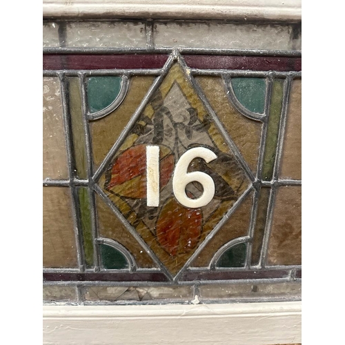 699 - A selection of three leaded stained glass panels, one featuring the number 16. 103x30