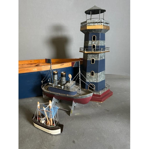 745 - A selection of maritime models. Three boats and a lighthouse