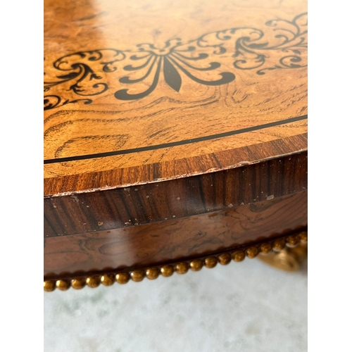 75 - A Regency style centre table, three ornate scrolling legs on a concave platform base with carved scr... 