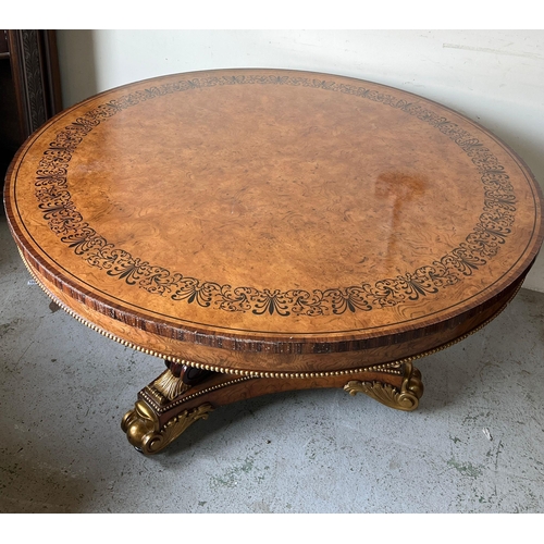 75 - A Regency style centre table, three ornate scrolling legs on a concave platform base with carved scr... 