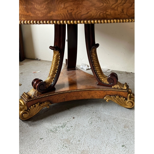 75 - A Regency style centre table, three ornate scrolling legs on a concave platform base with carved scr... 