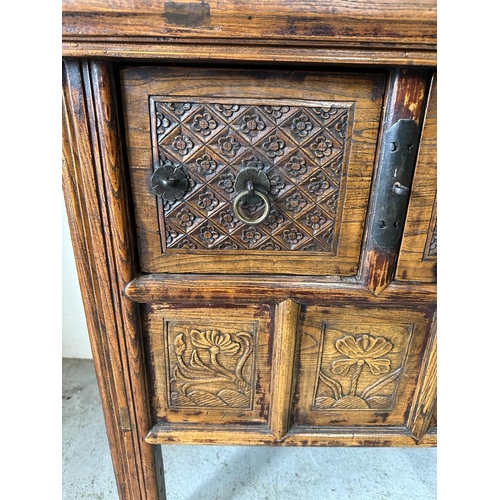 85 - A vintage Burmese two drawer wine table with carved floral detail (H85cm W108cm D55cm)