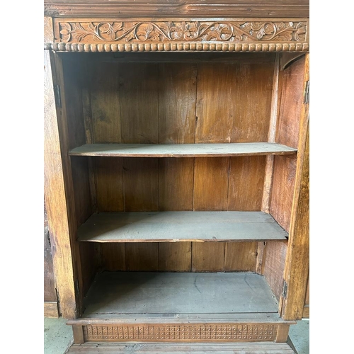 92 - A hand carved vintage oak two door cupboard on raised feet with two inner shelves AF (H166cm D40cm W... 