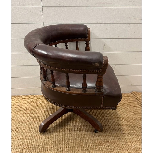 95 - An late Victorian oak framed Captain chair upholstered in burgundy leather