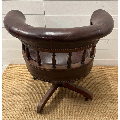 95 - An late Victorian oak framed Captain chair upholstered in burgundy leather