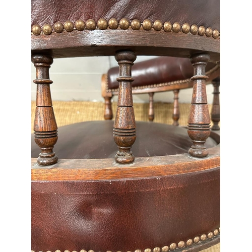 95 - An late Victorian oak framed Captain chair upholstered in burgundy leather