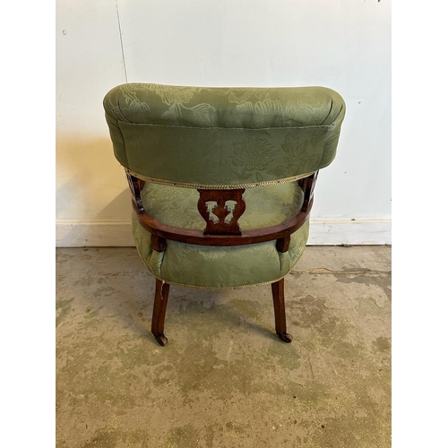 107 - A Victorian style oak framed tub chair on castors with green upholstery