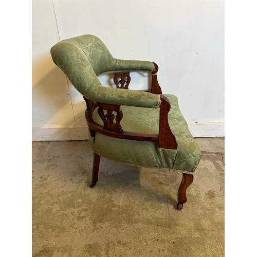 107 - A Victorian style oak framed tub chair on castors with green upholstery