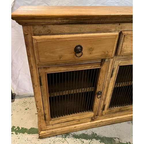 144 - A pine sideboard with three drawers and cupboards under with metal grill fronts (H91cm W153cm D45cm)