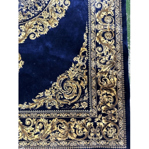 153 - A silk rug with blue grounds and gold scrolling border and central scrolling medallion 148x100