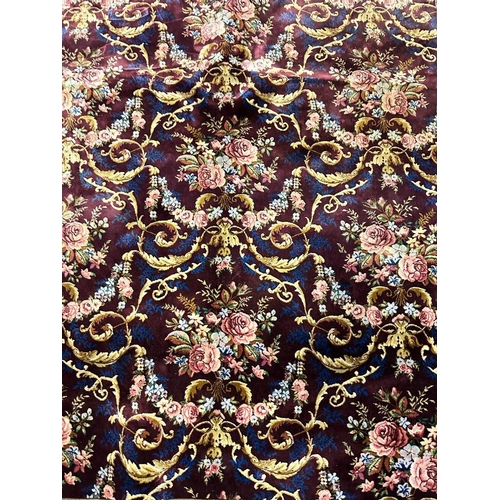 156 - A silk rug with burgandy grounds floral blue ground border and central floral motif 148x100