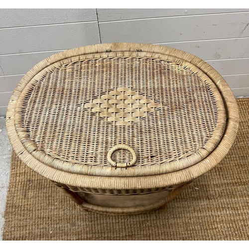 18 - An oval wicker side table (H75cm W54cm D35cm)