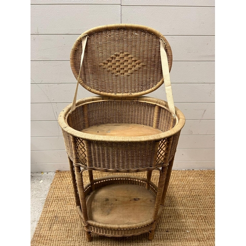 18 - An oval wicker side table (H75cm W54cm D35cm)