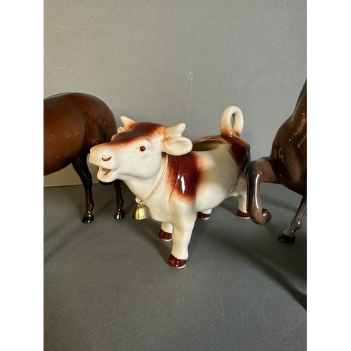 319 - A selection of three Beswick figures and a cow creamer