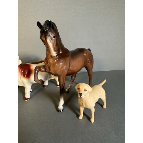 319 - A selection of three Beswick figures and a cow creamer