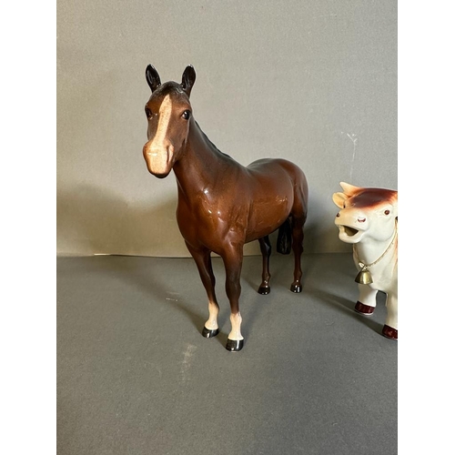 319 - A selection of three Beswick figures and a cow creamer