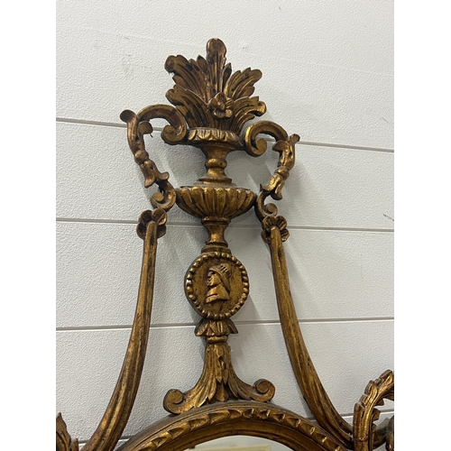 384 - A neoclassical style oval giltwood mirror (H120cm W64cm)