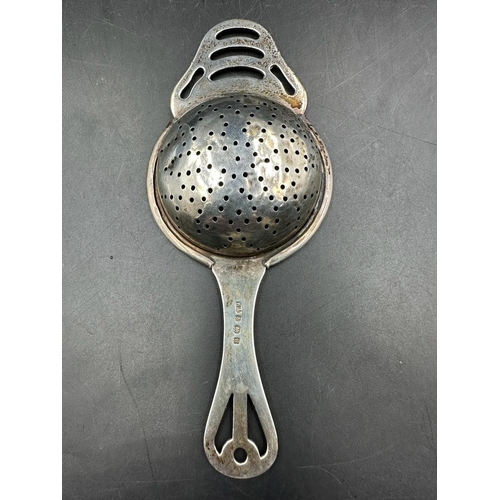 421 - A silver tea strainer and a pair of hallmarked silver sugar nips.