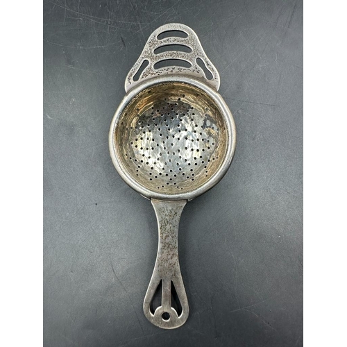 421 - A silver tea strainer and a pair of hallmarked silver sugar nips.