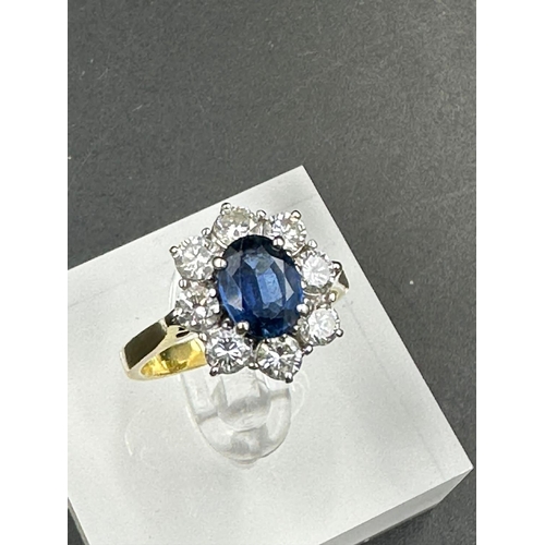 487 - A sapphire and diamond cluster ring  on an 18ct (750) shank.