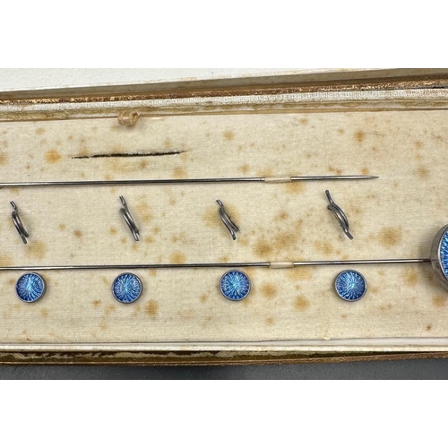 493 - An case set of blue enamel hat pins and fasteners on white metal