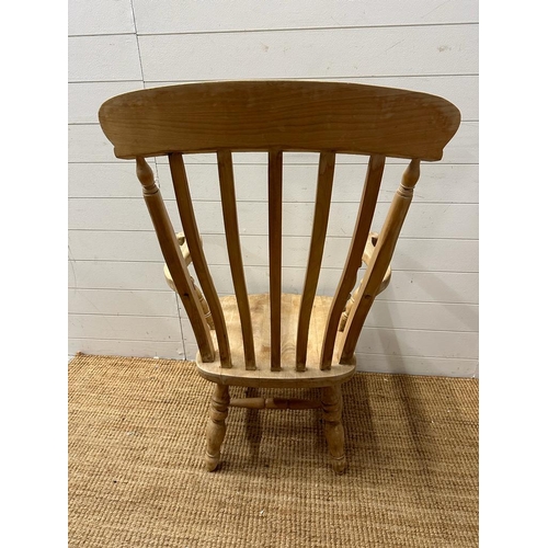 62 - A farm house slat back arm chair on turned legs and cross stretchers