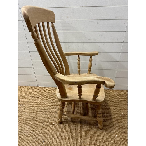 62 - A farm house slat back arm chair on turned legs and cross stretchers