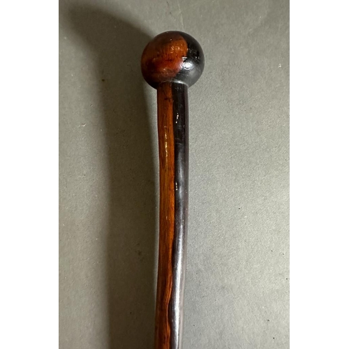 626 - A brass topped swagger or walking stick along with an iron wood Zulu Knobkerrie