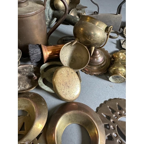 632 - A large selection of brass and copper curios including door knockers, syringe, horse brasses etc.