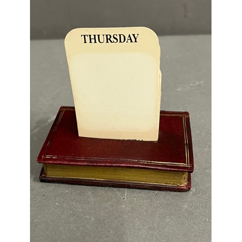 656 - A perpetual desk calendar on a stand in the form of a book (8cm x 6cm)