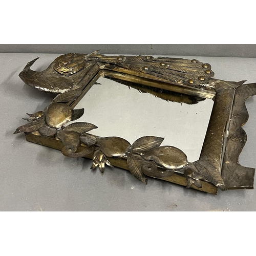 664 - A metal dressing table mirror with peacock to one side (43cm x 35cm)