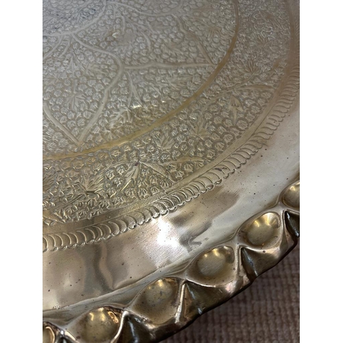 68 - A brass engraved Middle Eastern tea table on brass engraved stand. Diameter 82 height 38