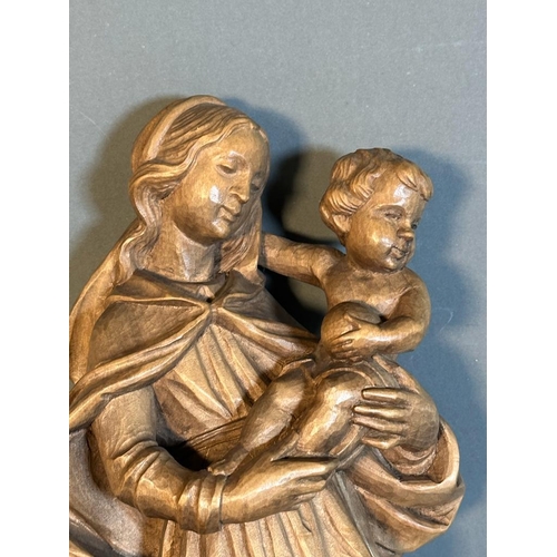 724 - A wooden carved wall hanging of the virgin mary with child