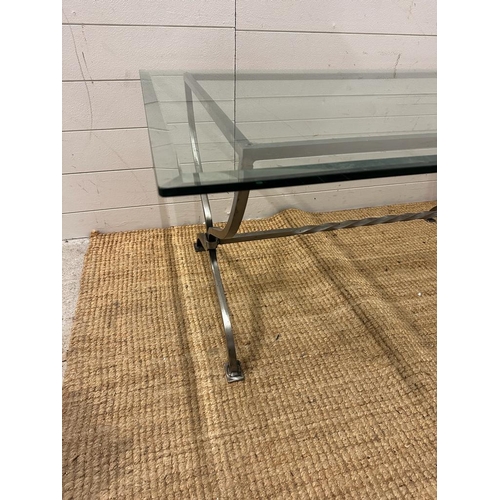 77 - A wrought iron glass topped coffee table with twisted central stretcher (H50cm W110cm D77cm)