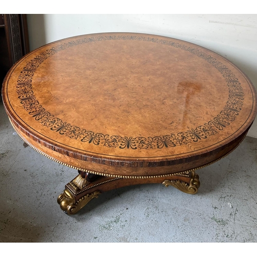 98 - A Regency style centre table, three ornate scrolling legs on a concave platform base with carved scr... 